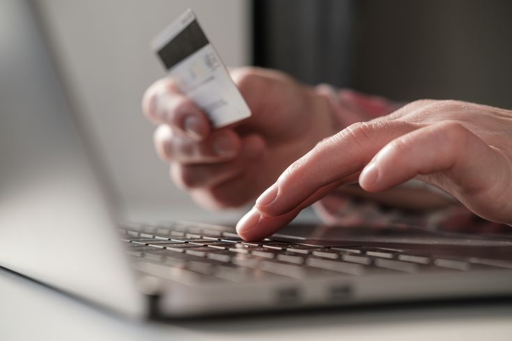 a person entering their bank card details on a computer