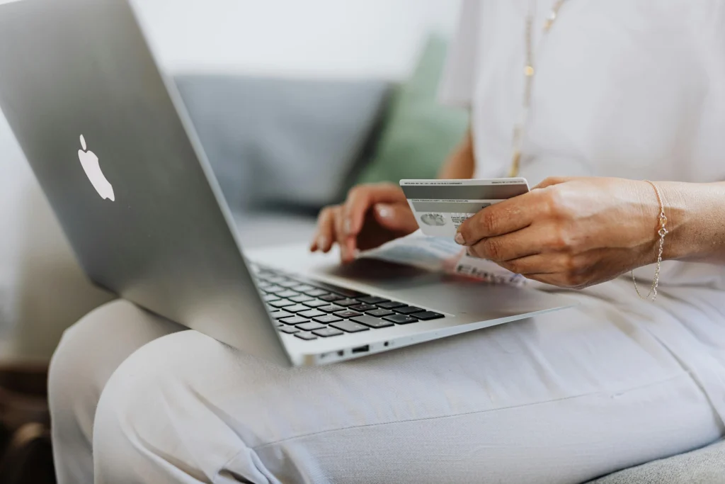 A picture of a shopper holding their credit card to pay for goods online.